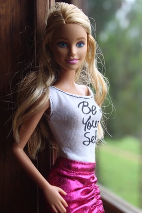 Barbie posing in a 'just be yourself' tank.